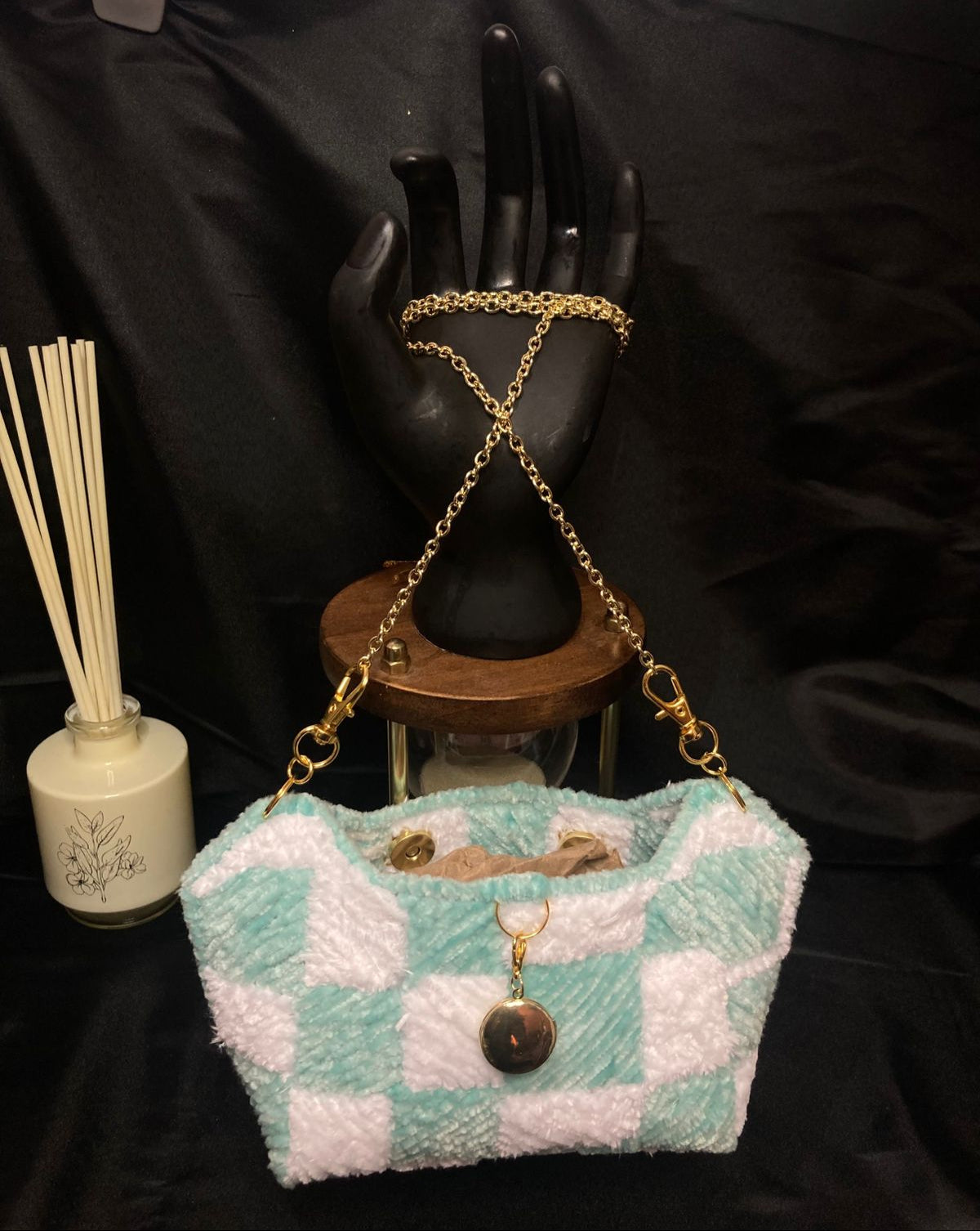Checkered handbag with gold chain on a black background
